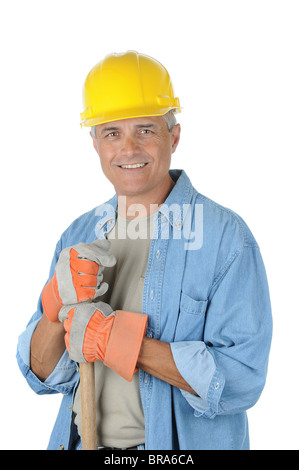 Workman holding onto the handle of his shovel. Man is wearing a hard hat and smiling at the camera. Isolated over white. Stock Photo