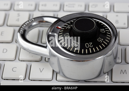 combination padlock sitting on a laptop computer keyboard Stock Photo