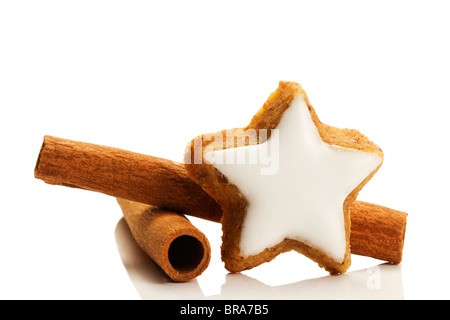 star shaped cinnamon biscuit and cinnamon sticks on white background Stock Photo