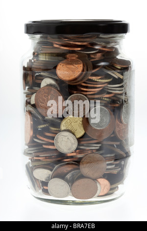 jar full of mixed sterling and euro coins in an old glass jar Stock Photo