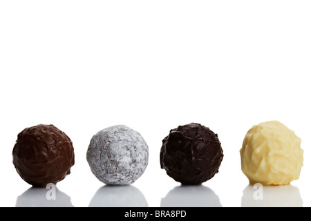 four different truffle pralines in a row on white background Stock Photo