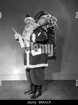 A Santa Claus carrying a bag full of gifts on his back isolated on ...