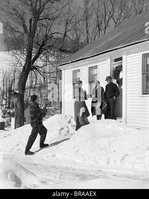 1950s FAMILY VISITING RELATIVES AT CHRISTMAS BEING GREETED AT FRONT DOOR Stock Photo