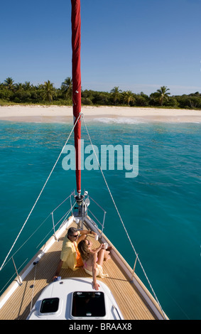 Couple relaxing on the bow of a yacht in the British Virgin Islands, Caribbean. Model and Property released Stock Photo