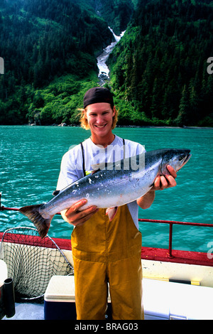 Fishing Charter Teenager Cleaning salmon Fish in Valdez Alaska USA Stock Photo