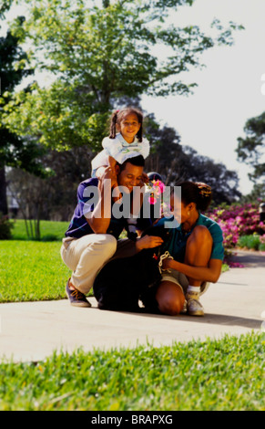 Young black african american couple with young daughter and dog near home relaxing together and caring for each other Stock Photo