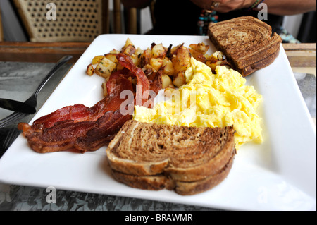 Well cooked bacon with scrambled egg breakfast Stock Photo