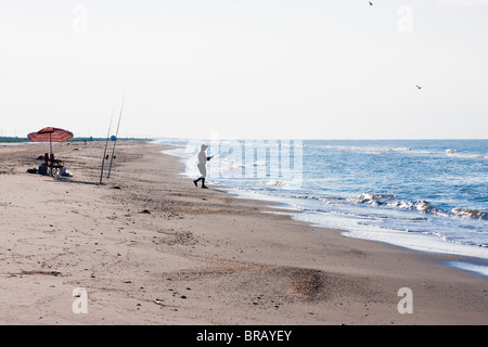 Silhouette of man fishing in the morning on Holly Beach near Cameron, Louisiana on the Gulf Of Mexico. Stock Photo