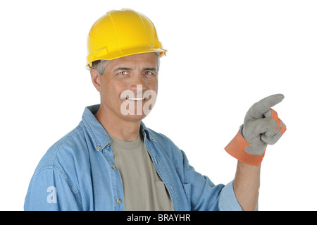 Construction worker wearing a yellow hard hat pointing while he smiles at the camera. Stock Photo