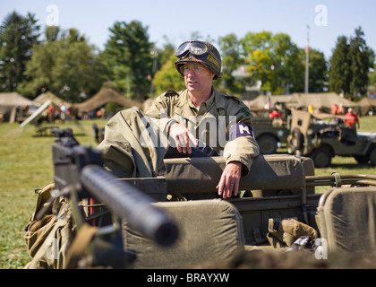 WWII era US Army soldier standing behind a Browning .30 caliber 1919A4 light machine gun mounted on a Jeep Stock Photo