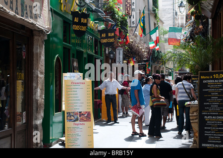 Restaurants and tourists in small street in Latin Quarter, Waiter asking people in, Paris, France Stock Photo