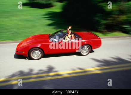 Mature Caucasian Couple Waving in Luxury 1991 Corvette Convertible Sports Car, USA Stock Photo