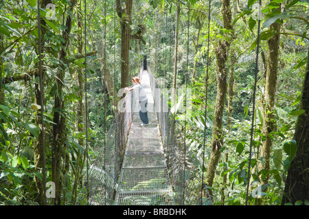 Man standing on hanging bridge in rainforest,, La Fortuna, Arenal, Costa Rica, Central America Stock Photo