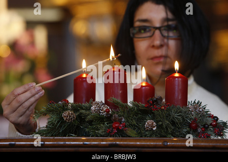 Woman lighting Advent candles, Saint-Nicolas de Veroce, Haute Savoie, France Stock Photo