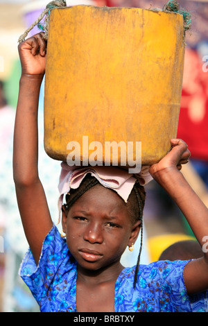 Children carrying heavy pail outdoors Stock Photo - Alamy