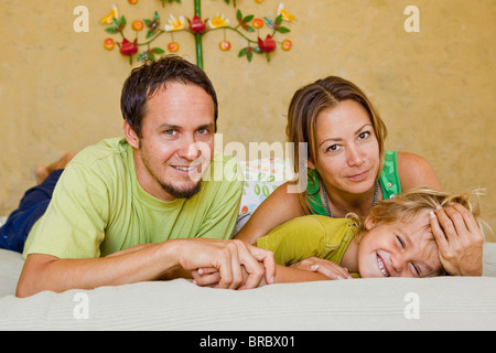 family cuddling on bed Stock Photo