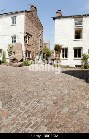 The cobbled lane in front of the pink granite memorial to Adam Sedgwick in the Main Street of the  village of Dent, Cumbria Stock Photo