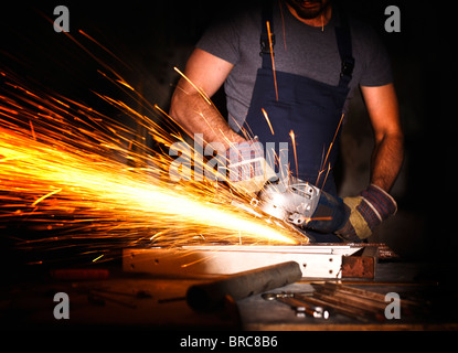 handyman work in factory with electric grinder Stock Photo