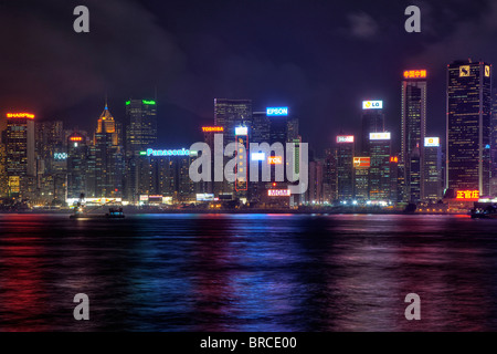 Tall buildings on Hong Kong Island city centre as seen across the harbour from Tsim Sha Tsui on Kowloon side at night Stock Photo