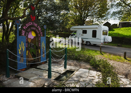 Motorhome driving through Tissington during well dressing week, Peak District National Park, Derbyshire. Stock Photo