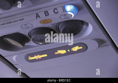 Overhead panel on a passenger jet aircraft with both the 'fasten seatbelt' and 'no smoking' warning lights switched on. Stock Photo