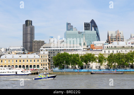 A Metropolitan Police Launch on the River Thames, with City of London Buildings in the Background, London, England, UK Stock Photo