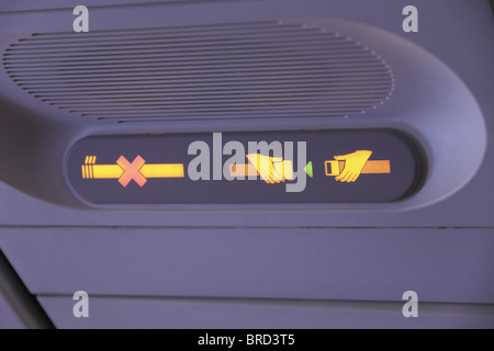 Overhead panel on a passenger jet aircraft with both the 'fasten seatbelt' and 'no smoking' warning lights switched on. Stock Photo