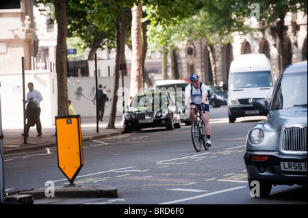 Cyclist negotiating traffic in London Stock Photo