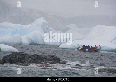 Tourists in zodiac offshore among icebergs, Cuverville Island, Antarctica 