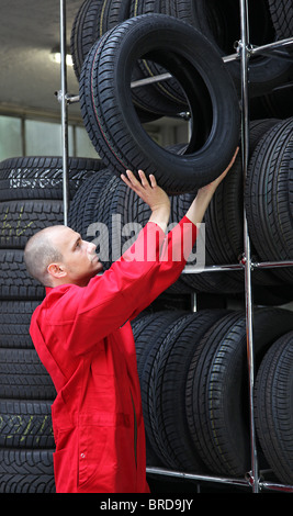 A mechanist working hard in a tire workshop. Stock Photo