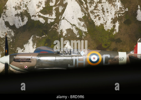 a spitfire seen through a cockpit flying along the white cliffs of Dover England taken on the 70th anniversary battle of Britain Stock Photo