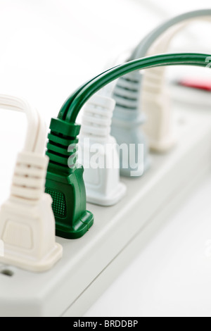 Many plugs plugged into electric power bar Stock Photo