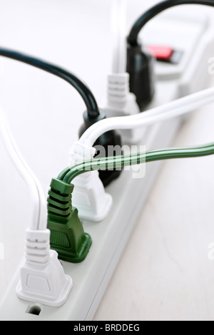 Many plugs plugged into electric power bar Stock Photo