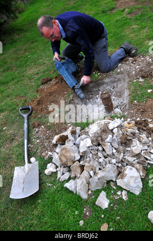 Jackhammer, Man using a pneumatic drill or jackhammer tool to breakup concrete Stock Photo