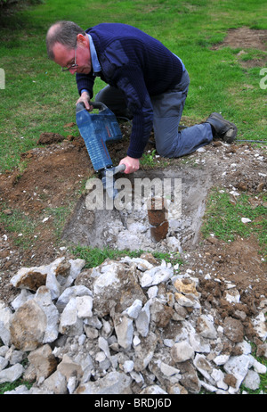 Jackhammer, Man using a pneumatic drill or jackhammer tool to breakup concrete Stock Photo