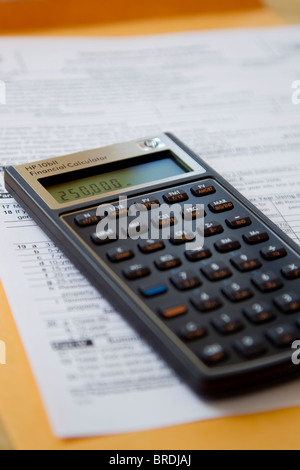 Calculator calculating income taxes on tax form, expenses and income Stock Photo