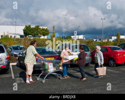 Shoppers talking in supermarket car-park - France. Stock Photo