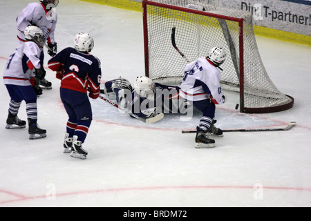 10-year old children scoring a goal while playing ice-hockey in Sweden. Stock Photo