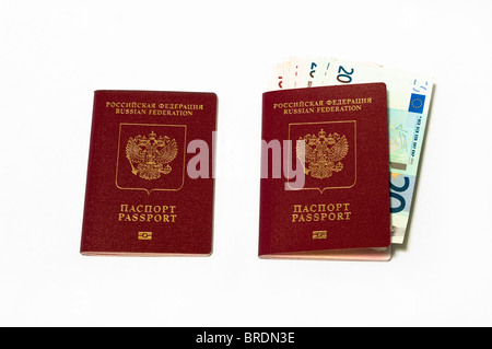 Two red Russian passports and euro cash small banknotes in one.  On white background Stock Photo
