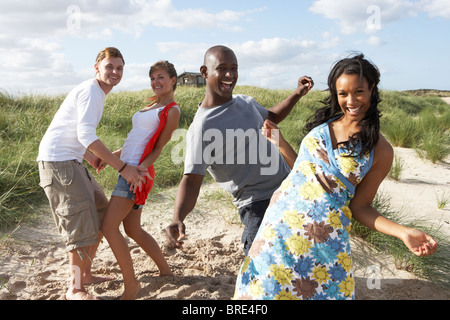 Group Of Young People Having Fun Dancing On Beach Together Stock Photo