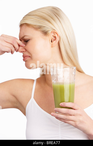 Young Woman Not Enjoying Healthy Drink In Studio Stock Photo