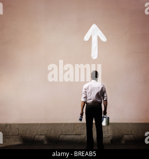 man with arrow painted on the wall Stock Photo