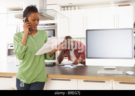 Young Couple Discussing Personal Finances In Modern Kitchen Stock Photo