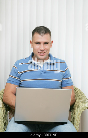 one young man working on a laptop computer at home Stock Photo