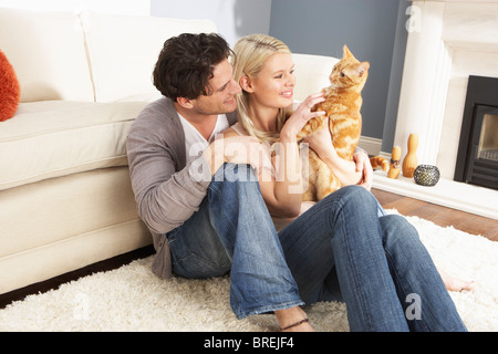 Couple Taking Playing With Pet Cat At Home Stock Photo