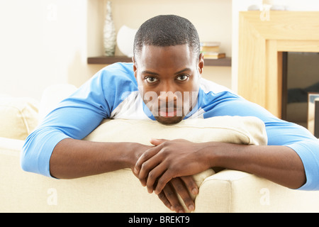 Man Relaxing On Sofa At Home Stock Photo
