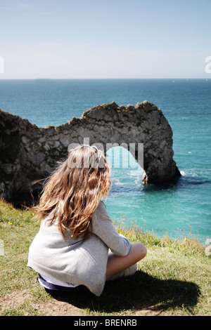 girl sat by Durdle Door,Dorset,England,UK