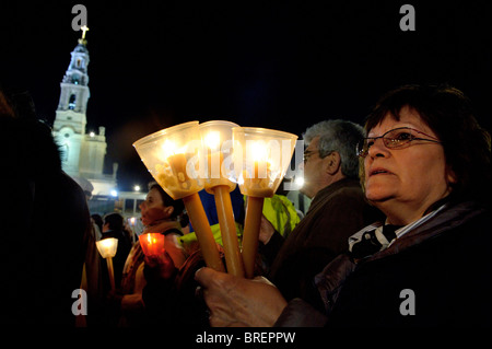 A pilgrim holds candles during the nighttime procession at the Our Lady of Fatima shrine in Portugal, May 2010 Stock Photo