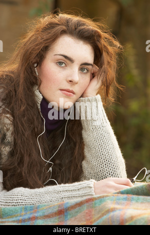 Portrait Of Beautiful Teenage Girl Outdoors Listening To MP3 Player In Autumn Landscape