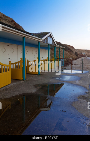 Beach huts reflected in a large puddle of water in Filey North Yorkshire England UK Stock Photo